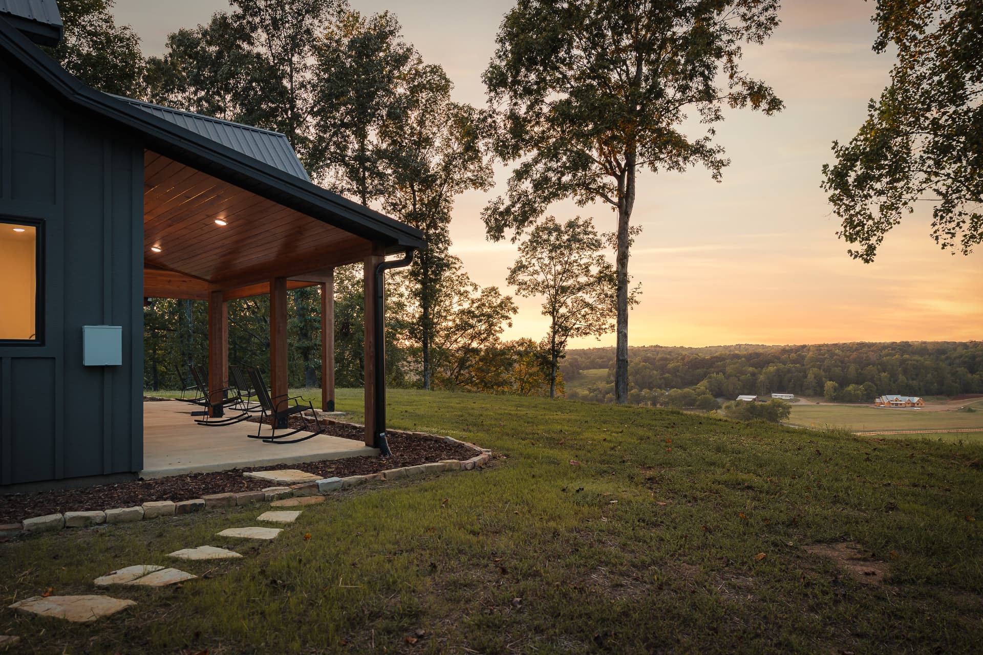 Rocking chairs on the covered porch of the Ridge House at sunset, overlooking the Tennessee valley